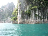 The limestone karts rise vertically from the blue-green water.